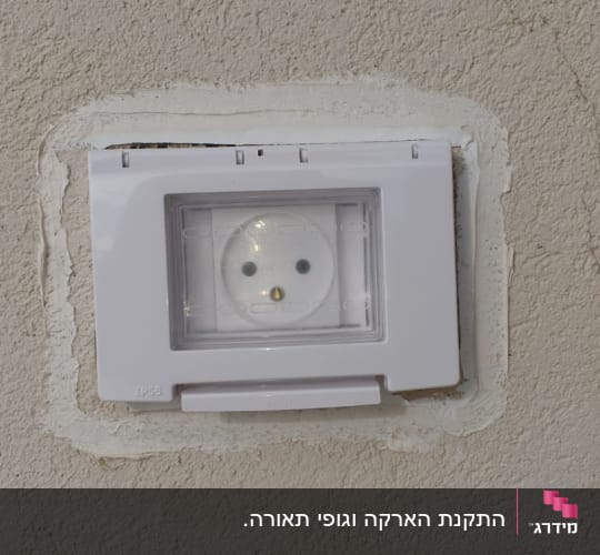 שקע חשמל עם כיסוי פלסטיק שקוף על קיר